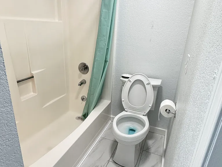 Recently renovated guest bathroom with bathtub, in unit washer and dryer and tile flooring.