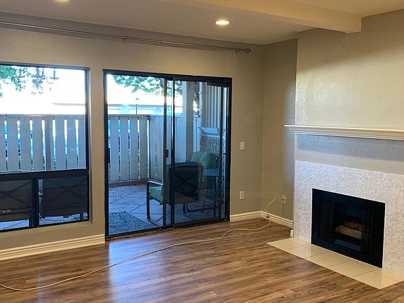 Main living room with recessed lighting, gas fireplace, and access to private patio