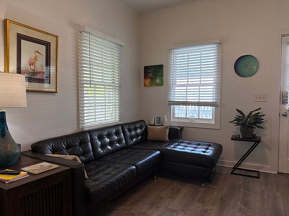 Living room couch with separate leather recliner and flat screen tv.