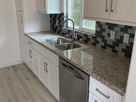 Kitchen remodel 10 months ago with new granite countertops, elegant glass backsplash, white shaker cabinets, and a stainless steel dishwasher inside and out. Kitchen sink window has a view of nature!