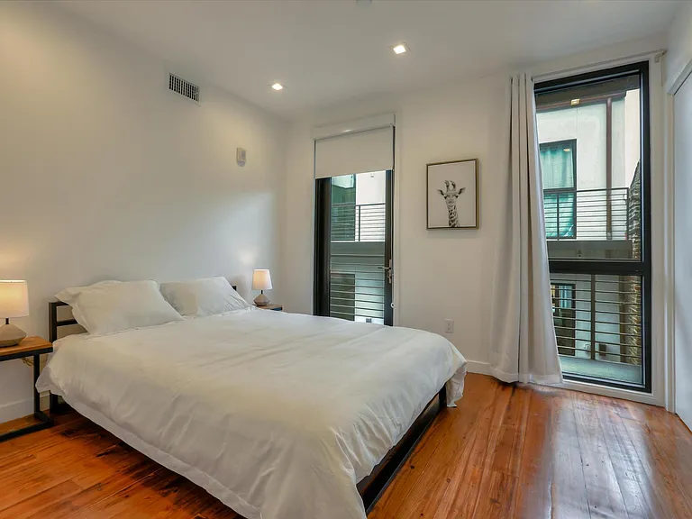The second guest bedroom also features floor to ceiling doors/windows and terrace access.