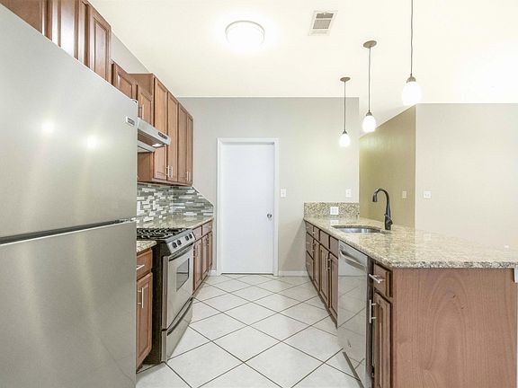 Kitchen featuring a brand new fridge, granite countertops and stainless steel appliances!