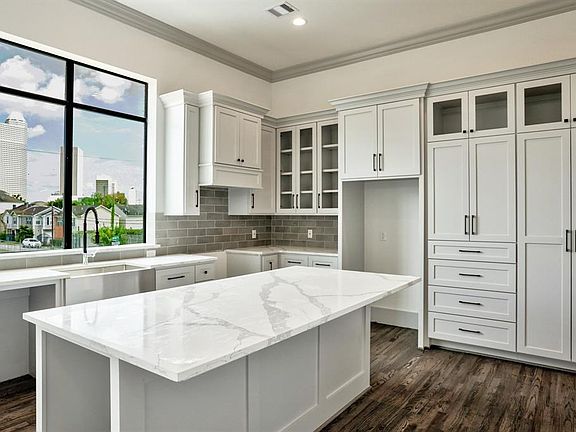 The kitchen is located on the second floor. The kitchen cabinets are custom-built Shaker-style with satin nickel knobs and pulls, Quartz countertops and soft-closed drawers and cabinets. The kitchen will be installed with a 5-burner Bosch gas range, 