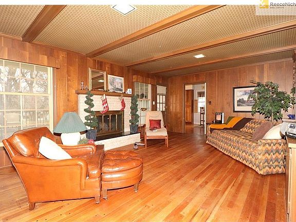 Huge Family Room With Fireplace & Pegged Wood Floor Looking Toward Kitchen & Rear Deck.
