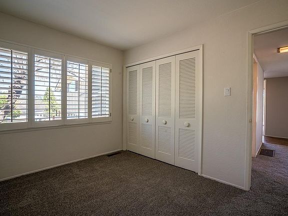 Smaller bedroom. Closet has storage cabinets on bottom not seen. Note the tree in front of home peeking in.