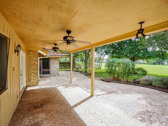 Large covered back patio with mature trees and golf course views