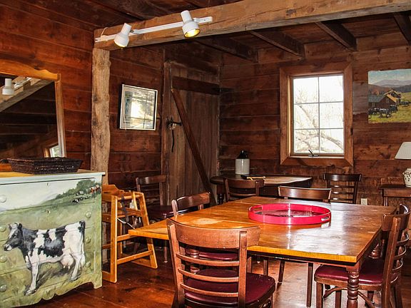 Open dining room beside living room shows post and beam construction.