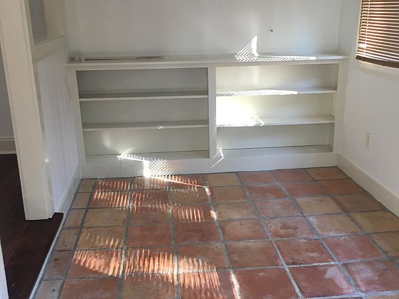Sun room or Study with Mexican tile floors and bookcases.