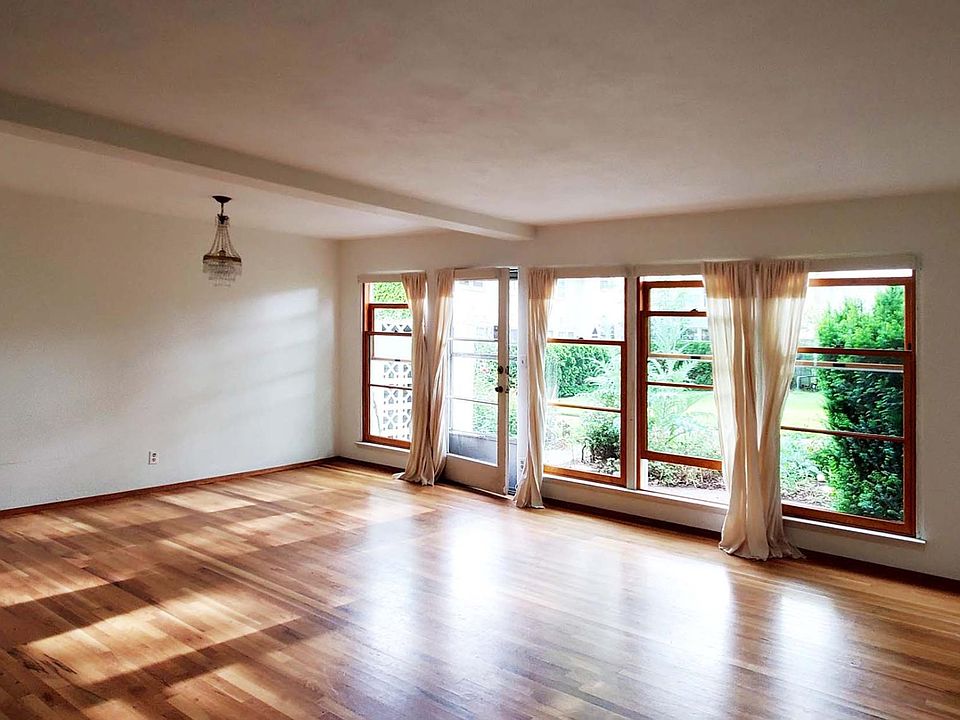 Living / Dining Room with floor to ceiling wood windows that open to private courtyard.
