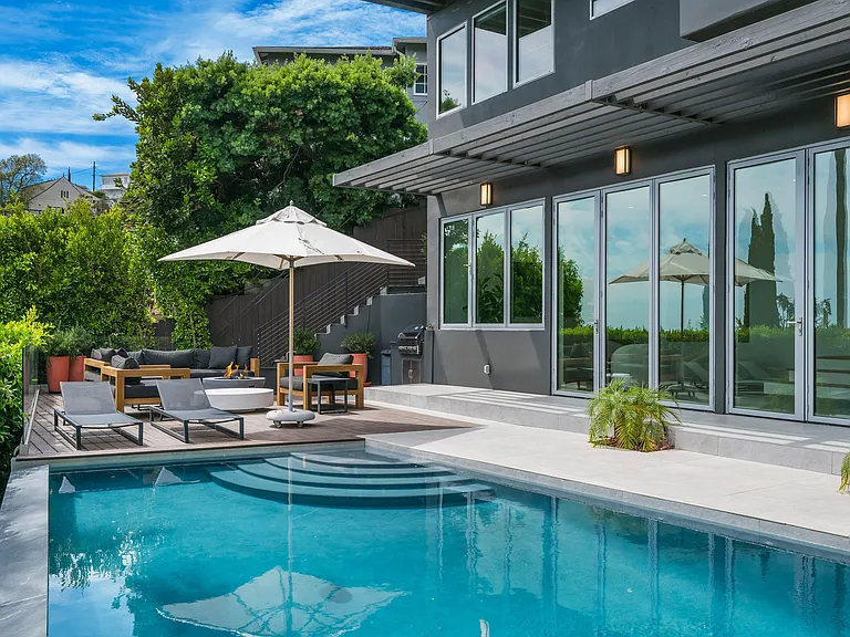 Outdoor area with pool, outdoor seating, indoor-outdoor fun room connecting the pool to the inside of the home.