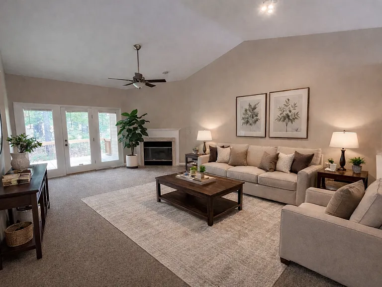 Expansive living space with vaulted ceiling and gas fireplace. Leads out to deck.