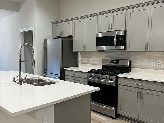 Beautiful kitchen featuring quartz countertops and stainless steel appliances, including a gas stove!