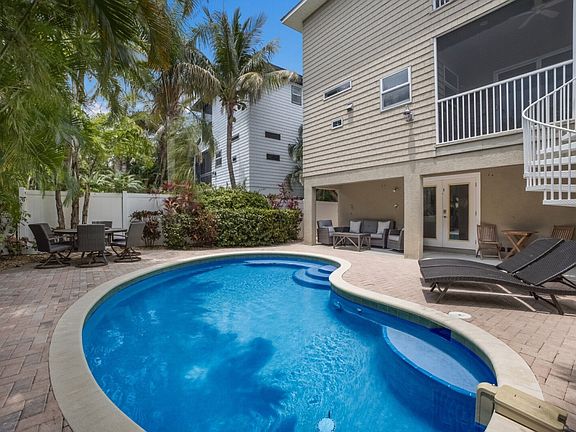Back of the house featuring the heated pool, three comfortable lounge areas, and a gourmet grill for outdoor entertaining.