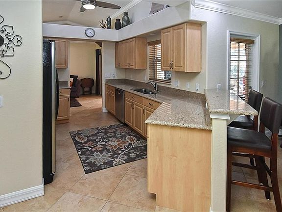 Kitchen features light oak cabinets, quartz counter tops and stainless-steel appliances.