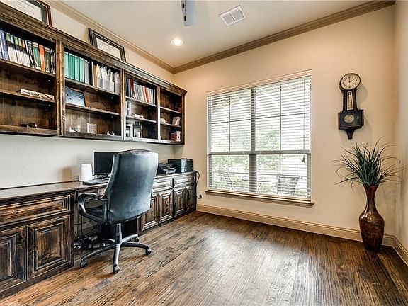 Handsome study with huge wall of built in cabinets and shelving.  Lots of crown molding and hand scraped wood flooring complete this room!