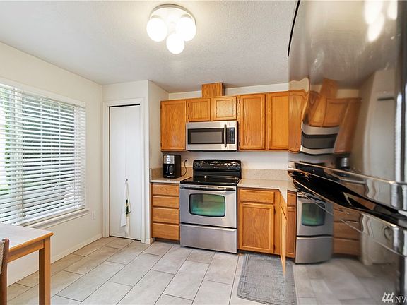 Kitchen to the right of the front entrance. Kitchen has newer appliances, upgraded quartz counter tops and tile flooring. 