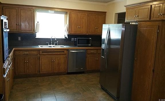 Stainless steel kitchen appliances in this spacious kitchen are less than two years old. Tile two years old. Fridge and microwave stay also.