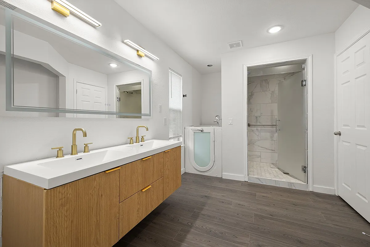 Luxurious modern primary bathroom with a sitting jet tub and walk in shower. Modern floating double sink vanity! - 2204 Founder Dr