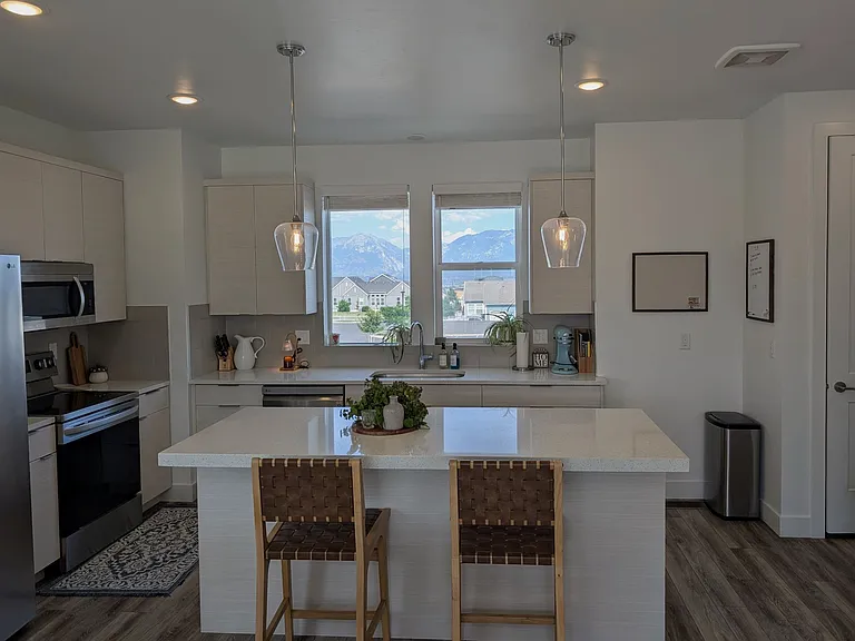 Large kitchen island with quartz countertops and ample storage in cabinets and drawers
