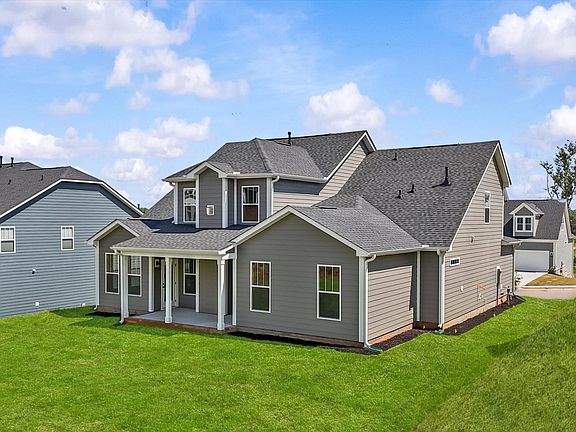 Rear exterior of home with covered back porch Gray exterior home with large windows at The Grange by