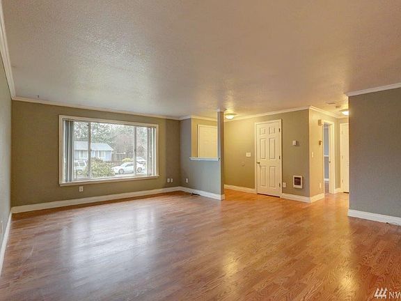 Living room is at the front of the home with newer laminate flooring and decorator paint colors. 