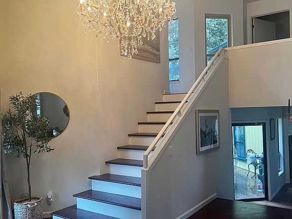 Stairs to second story with three bedrooms, two full baths, and linen closet