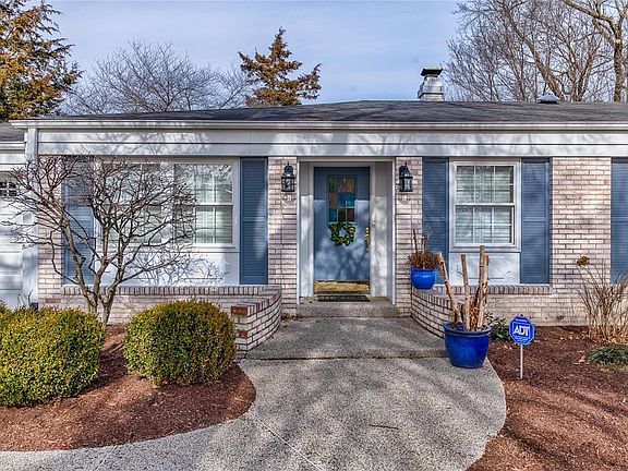 Fantastic curb appeal with white brick exterior, aggregate front sidewalk and beautifully landscaped front