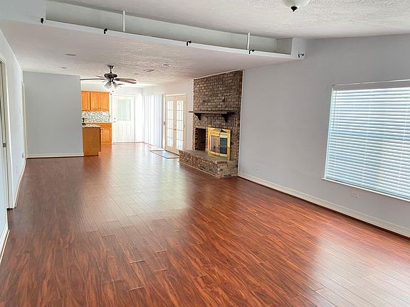 The living room area is massive with plenty of natural light. Also features a fireplace.