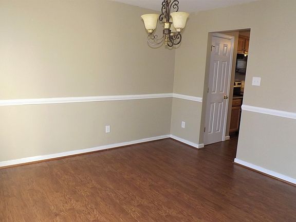 Formal Dining Room With Laminate Wood Floors & Chair Rail