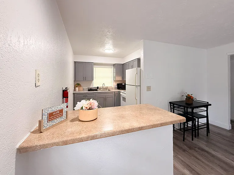 Open kitchen with breakfast bar, ample cabinetry, and full appliance set, plus an adjacent dining nook for easy meals.