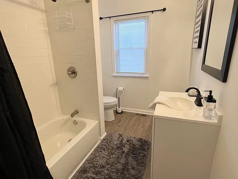 Full bath with subway tile surround, conveniently located near bedrooms
