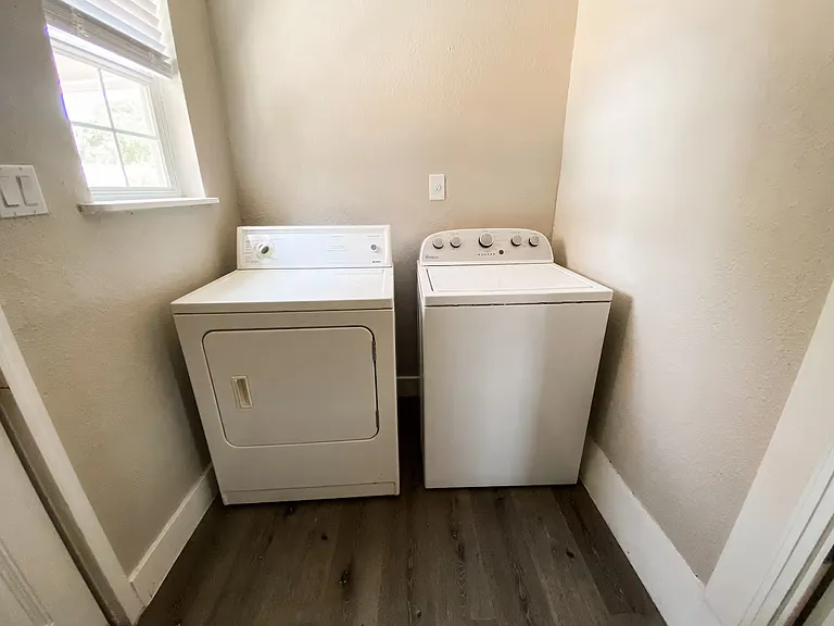 Dedicated laundry room with full-size washer and dryer included, offering added convenience and extra storage space.