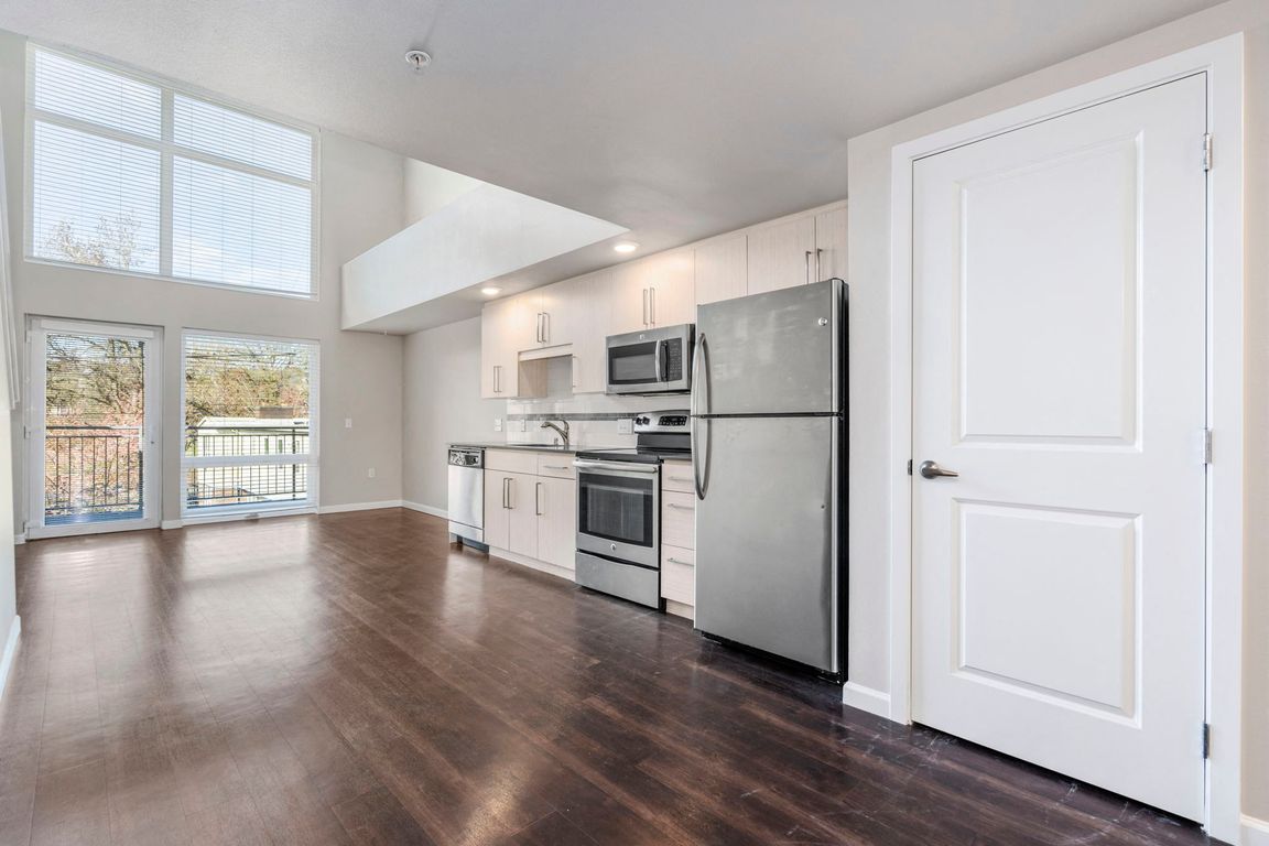 Living room with hardwood floors and a large window.