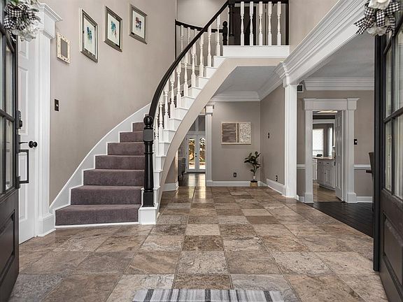 The grand foyer sets the tone for your 2-story estate - travertine tile, custom crown-molding, high ceilings, a spiral staircase and a clean, modern color palate.