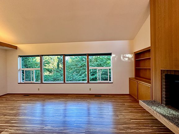 This is the living room facing the windows. There is a wood burning fireplace and storage area built in.