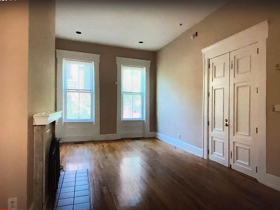 Living room with 12 foot ceilings, fireplace and southern exposure windows from kitchen