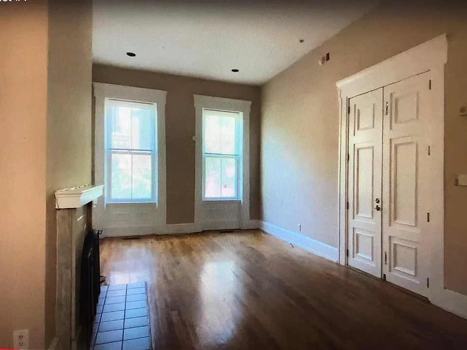 Living room with 12 foot ceilings, fireplace and southern exposure windows from kitchen