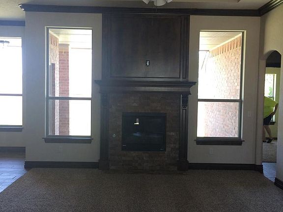 Lush carpet, woodwork and firplace make for an inviting livi