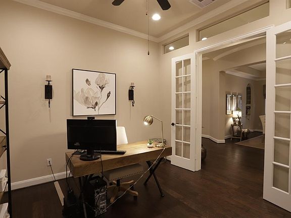 Beautiful study with glass French doors, crown molding, ceiling fans, wood floors, and transom windows! Working from home has never been so beautiful in this large study.