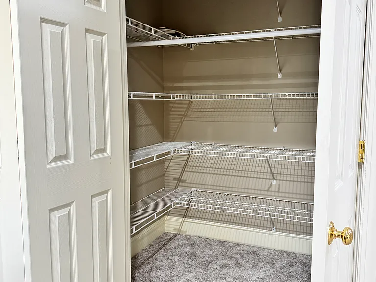 Generously sized walk-in closet with plenty of hangers and built-in storage.