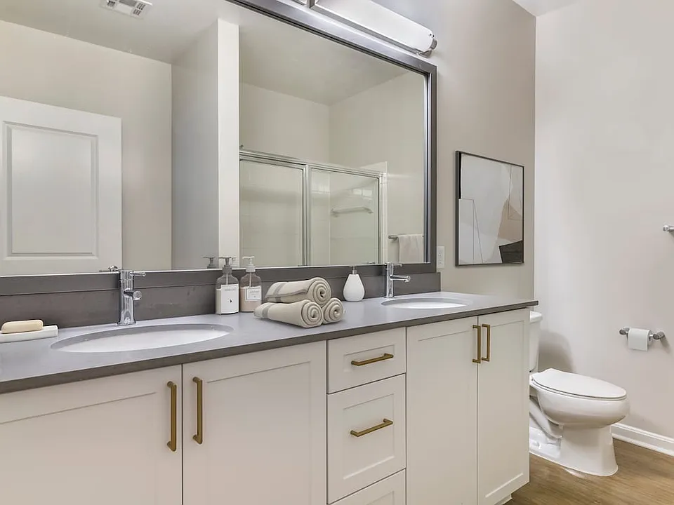 Renovated Package II bath with grey quartz countertops, white cabinetry, and hard surface flooring