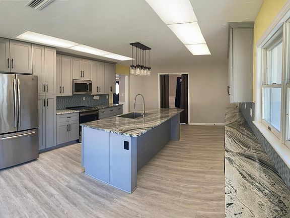 Kitchen with island sink and dishwasher, seating for 4