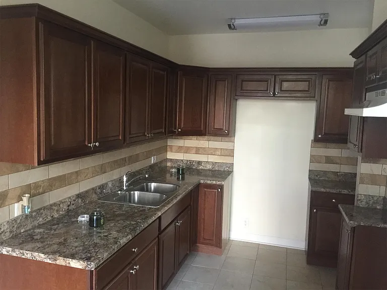Kitchen with stainless steel sink, backsplash porcelain tile and plenty of cabinet space