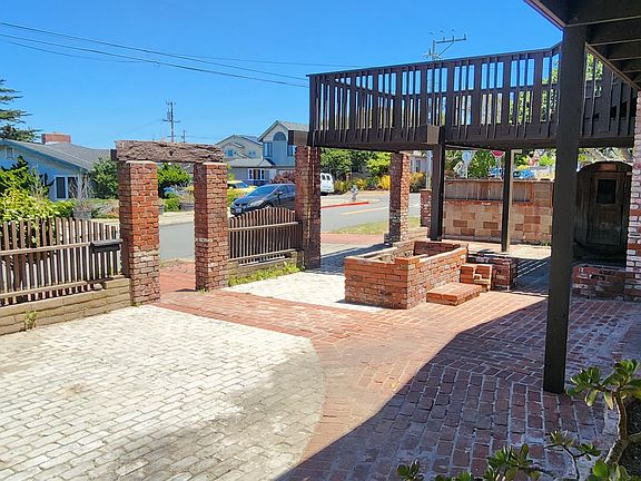 Large front yard with flower pots and firepit