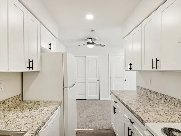 view of kitchen with white cabinets and granite counter tops and white appliances