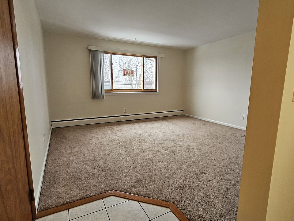 Spacious living room with plush carpet and large picture window.