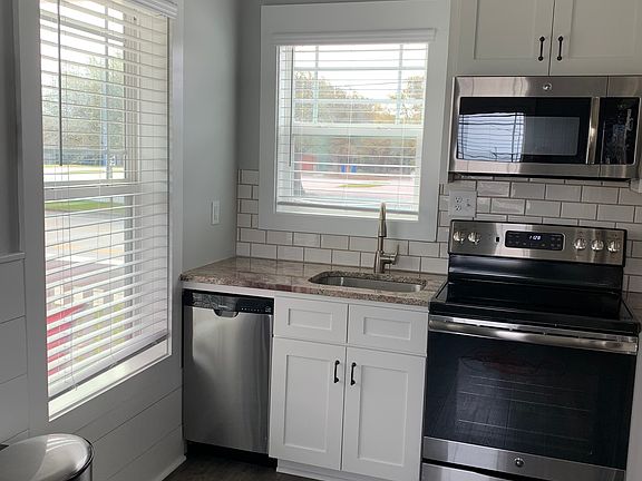 Full size kitchen with dishwasher, microwave, electric stove and oven.