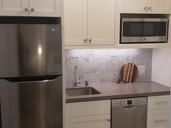 Marble back splash, microwave, dishwasher, hot plate and sink with garbage disposal.