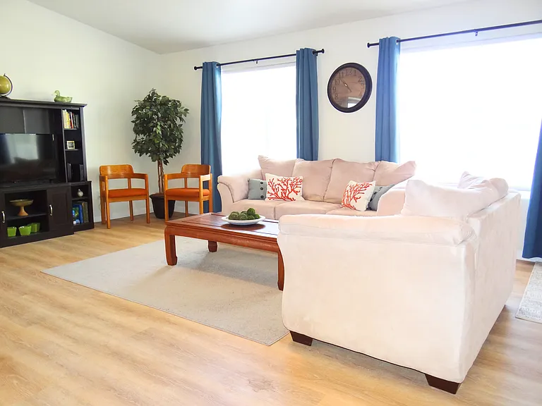 Cozy living room with comfy sofas and a sleek entertainment center featuring a smart TV.