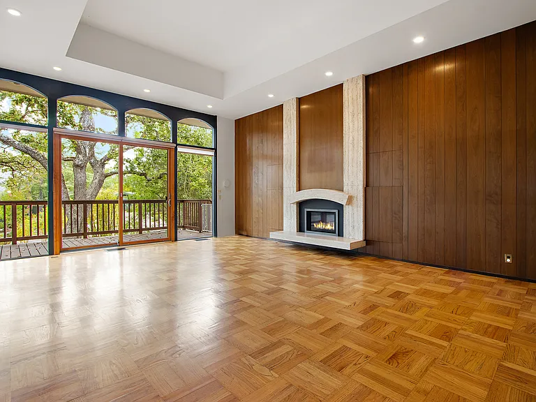 Living room with immaculate walnut paneling, travertine mantel and gas fire place